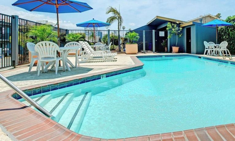 Outdoor pool with lounge chairs at Travelodge LAX By Wyndham.