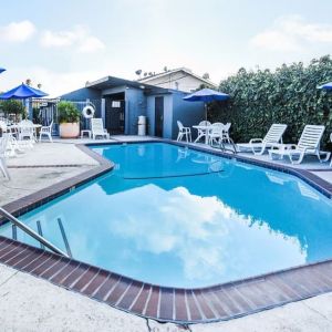 Outdoor pool with lounge area at Travelodge LAX By Wyndham.