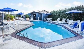 Outdoor pool with lounge area at Travelodge LAX By Wyndham.