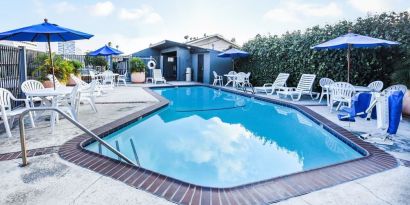 Outdoor pool with lounge area at Travelodge LAX By Wyndham.