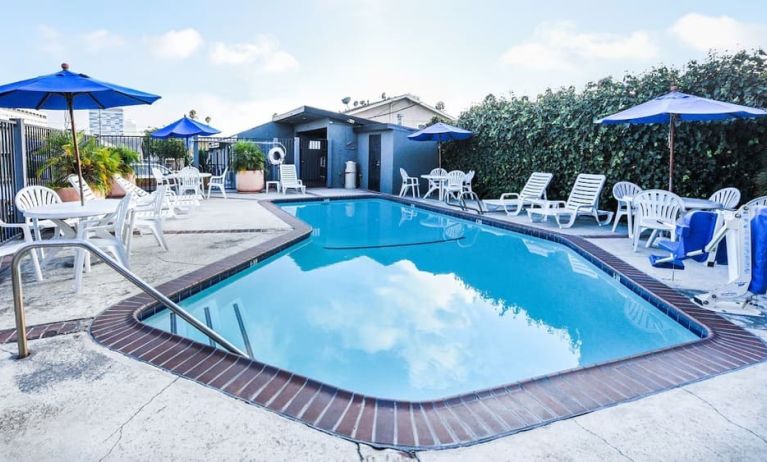 Outdoor pool with lounge area at Travelodge LAX By Wyndham.