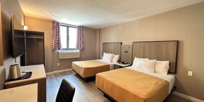Day use twin room with work desk at Regal Inn & Suites New York.