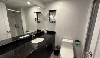 Private guest bathroom with shower and free toiletries at Regal Inn & Suites New York.