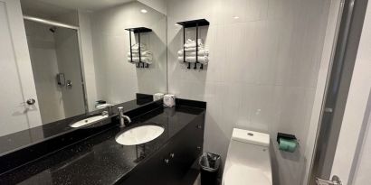 Private guest bathroom with shower and free toiletries at Regal Inn & Suites New York.