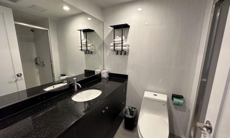 Private guest bathroom with shower and free toiletries at Regal Inn & Suites New York.