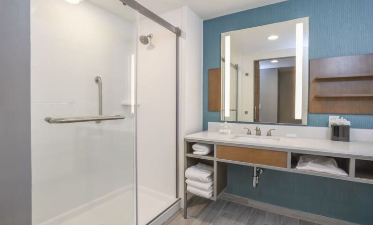 Private guest bathroom with shower and free toiletries at Hilton Garden Inn Cincinnati Midtown.