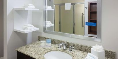 Private guest bathroom with shower and free toiletries at Hampton Inn Los Angeles-Orange County-Cypress.