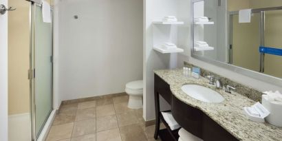 Private guest bathroom with shower and free toiletries at Hampton Inn Los Angeles-Orange County-Cypress.