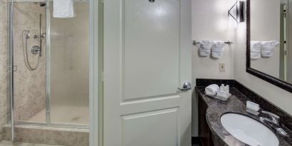 Private guest bathroom with shower and free toiletries at Homewood Suites By Hilton Agoura Hills.
