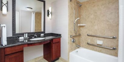 Private guest bathroom with combined shower and tub at Homewood Suites By Hilton Agoura Hills.