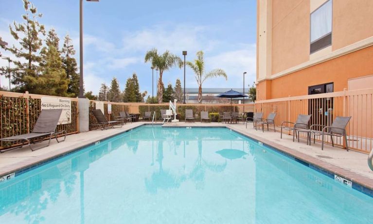 Outdoor pool with lounge chairs at Hampton Inn & Suites Clovis-Airport North.