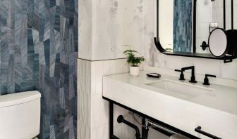 Private guest bathroom with shower and free toiletries at Kimpton Theta New York - Times Square.