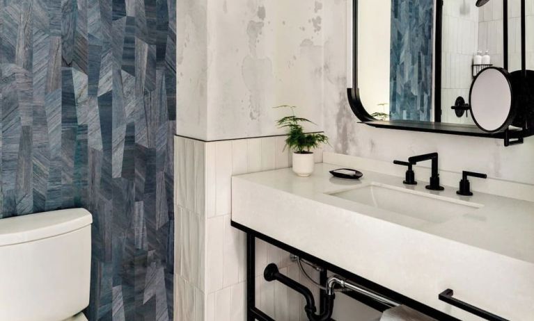 Private guest bathroom with shower and free toiletries at Kimpton Theta New York - Times Square.