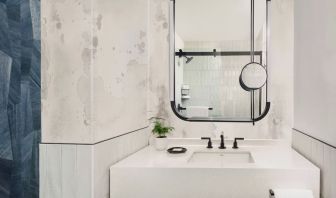 Private guest bathroom with shower and free toiletries at Kimpton Theta New York - Times Square.