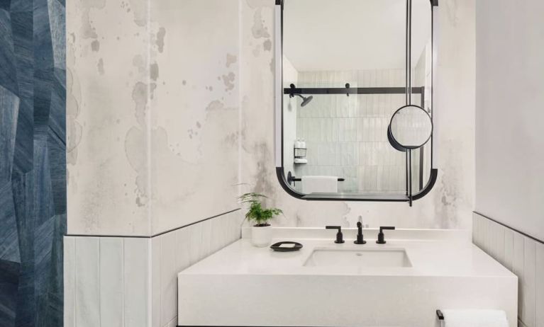 Private guest bathroom with shower and free toiletries at Kimpton Theta New York - Times Square.