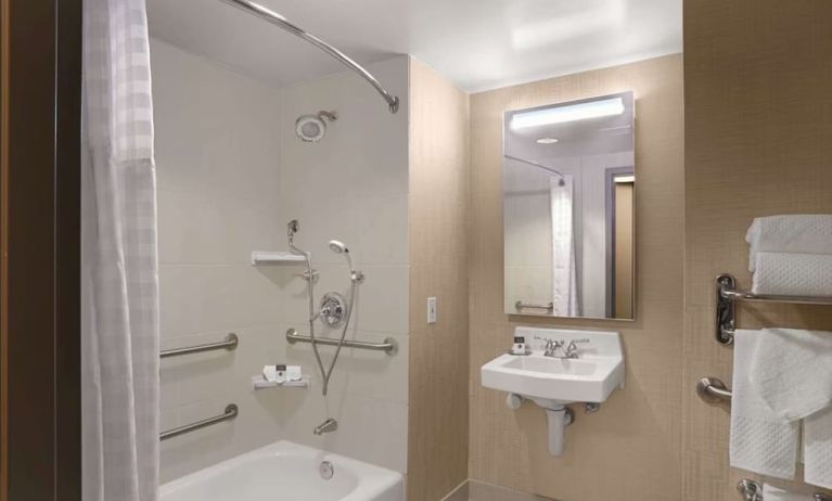 Private guest bathroom with combined shower and tub at DoubleTree By Hilton San Francisco Airport North Bayfront.
