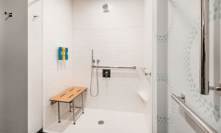 Accessible private guest bathroom with shower and free toiletries at 	Home2 Suites By Hilton Denver Downtown Convention Center.