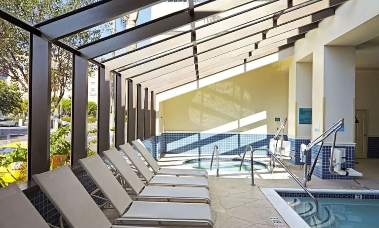 Indoor pool with jacuzzi and lounge area at Embassy Suites By Hilton Los Angeles-Intl Airport North.