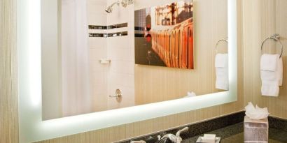 Private guest bathroom with shower and free toiletries at Hilton Newark Airport.