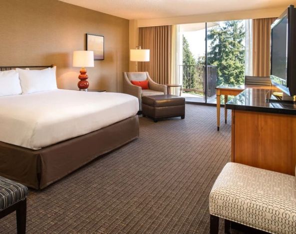 Comfortable king bedroom with balcony at the DoubleTree by Hilton Seattle Airport.