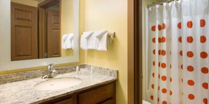 Private guest bathroom with shower and free toiletries at Sonesta Simply Suites Phoenix Scottsdale.
