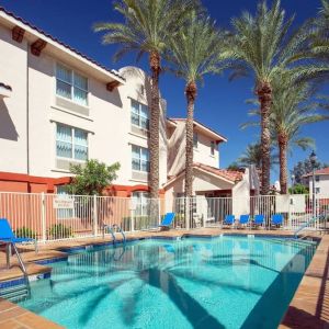 Outdoor pool with lounge chairs at Sonesta Simply Suites Phoenix Scottsdale.