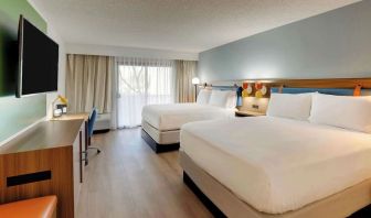 Day use twin room with work desk, TV screen and floor to ceiling windows at Sonesta Select Scottsdale At Mayo Clinic Campus.