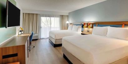 Day use twin room with work desk, TV screen and floor to ceiling windows at Sonesta Select Scottsdale At Mayo Clinic Campus.