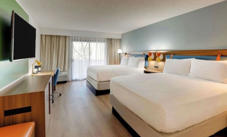 Day use twin room with work desk, TV screen and floor to ceiling windows at Sonesta Select Scottsdale At Mayo Clinic Campus.