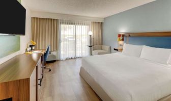 Day use room with king bed, work desk, sofa, TV screen and floor to ceiling window at Sonesta Select Scottsdale At Mayo Clinic Campus.