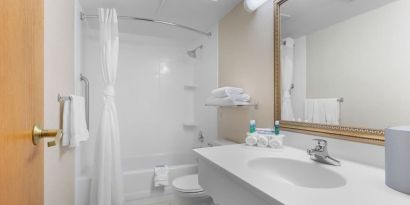 Private guest bathroom with combined shower and tub at Holiday Inn Express Chicago - Downers Grove.