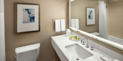 Private guest bathroom with combined shower and tub at Hilton Boston Logan Airport.