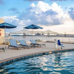 Outdoor pool with lounge seating and great city view at Hilton Baton Rouge Capitol Center.