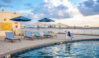 Outdoor pool with lounge seating and great city view at Hilton Baton Rouge Capitol Center.