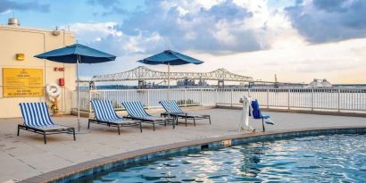 Outdoor pool with lounge seating and great city view at Hilton Baton Rouge Capitol Center.