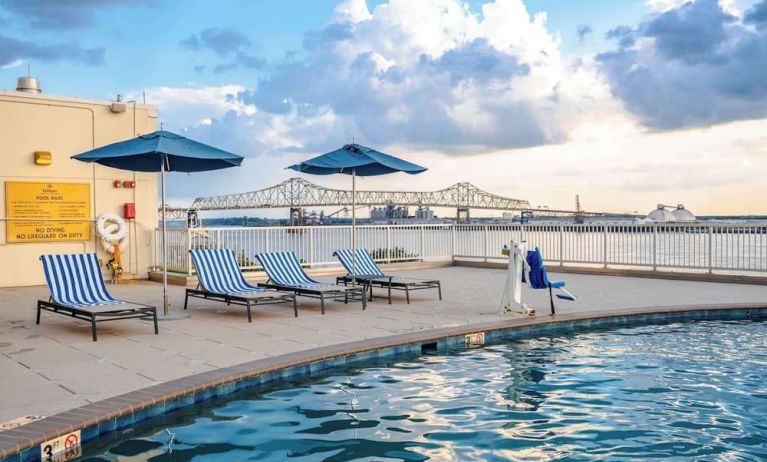 Outdoor pool with lounge seating and great city view at Hilton Baton Rouge Capitol Center.