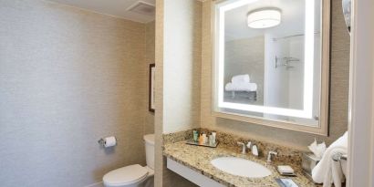 Private guest bathroom with shower and free toiletries at Hilton Baton Rouge Capitol Center.