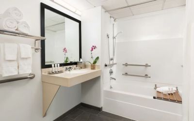 Guest bathroom with shower and tub at Hotel Studio Allston.