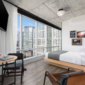 Delux king room with work desk and a view of the city at Moxy Boston Downtown.