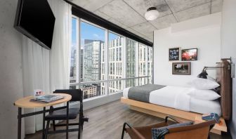Delux king room with work desk and a view of the city at Moxy Boston Downtown.