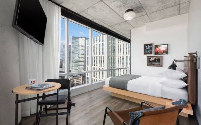 Delux king room with work desk and a view of the city at Moxy Boston Downtown.