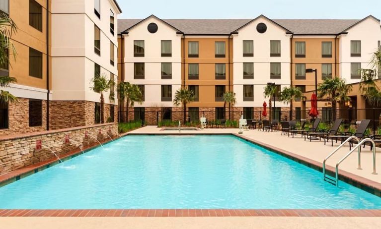 Outdoor pool with lounge seating at Homewood Suites By Hilton Shreveport / Bossier City, LA.
