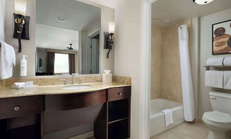 Private guest bathroom with combined shower and tub at Homewood Suites By Hilton Shreveport / Bossier City, LA.