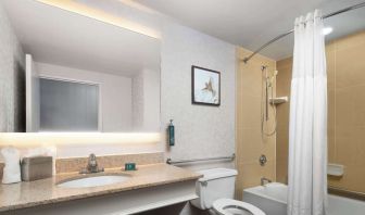 Private guest bathroom with combined shower and tub at DoubleTree By Hilton Hartford - Bradley Airport.