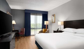 Day use room with floor to ceiling window, work desk, king bed and private bathroom at DoubleTree By Hilton Hartford - Bradley Airport.