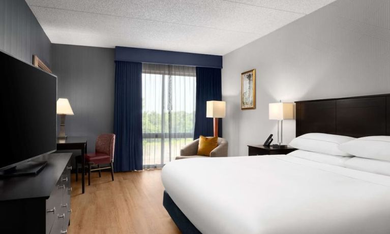 Day use room with floor to ceiling window, work desk, king bed and private bathroom at DoubleTree By Hilton Hartford - Bradley Airport.