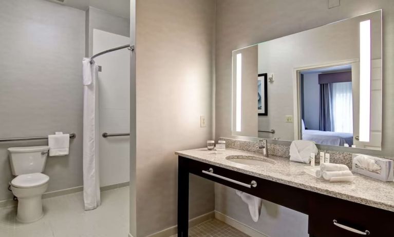 Private guest bathroom with shower and free toiletries at Homewood Suites By Hilton Newark-Cranford.