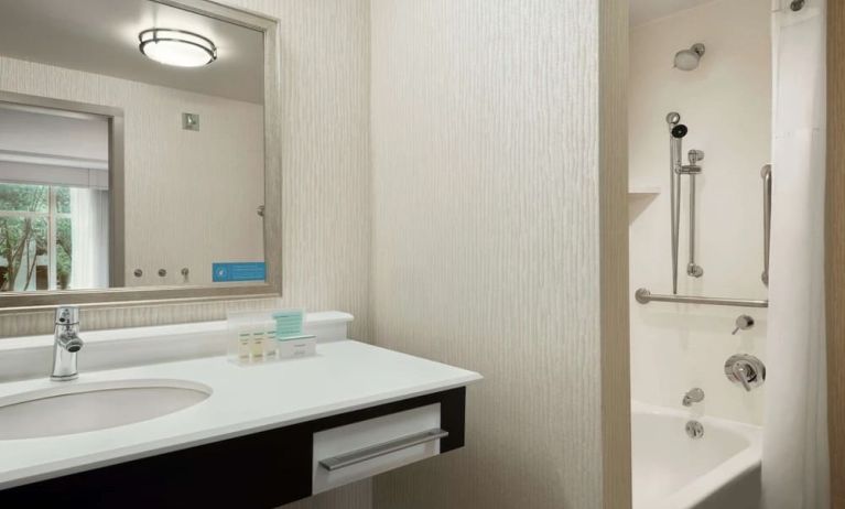 Private guest bathroom with combined shower and tub at Hampton Inn & Suites Rosemont Chicago O'Hare.