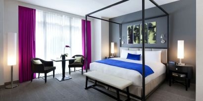 King bedroom with seating area and natural light at Royalton Park Avenue.