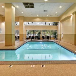 Relaxing indoor pool with seating area at Embassy Suites By Hilton Santa Clara Silicon Valley.